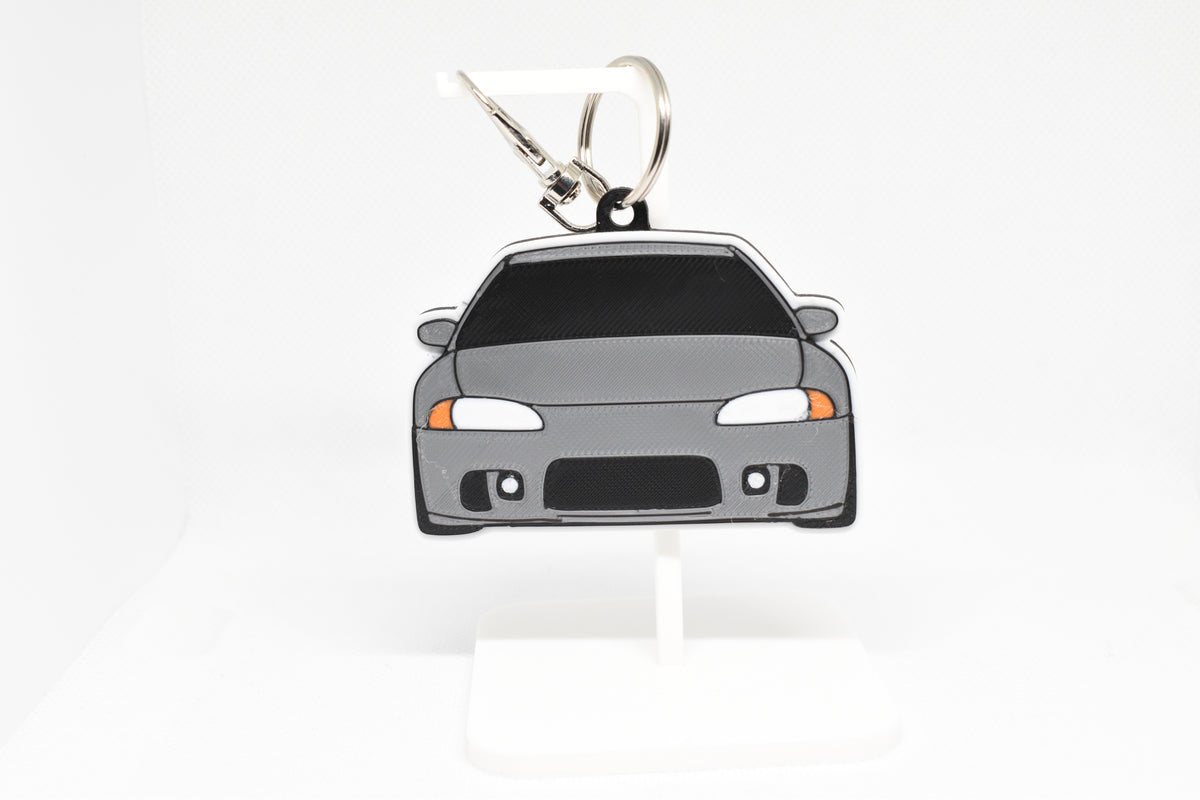 Pocket Motors Mitsubishi Eclipse 2nd Gen keychain displayed on a white stand with metal ring and clip.