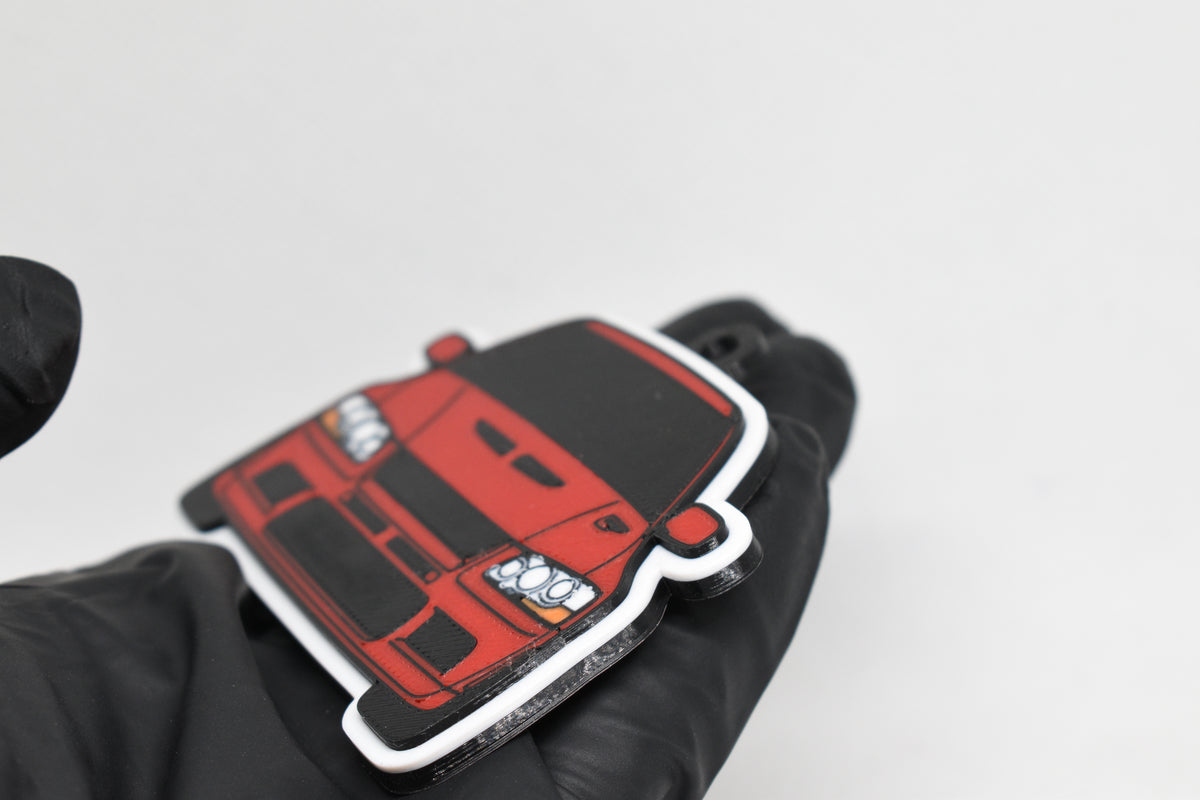 Side angle view showing 3D layered detail of red Mitsubishi Lancer Evolution 7 keychain by LayerPlay Pocket Motors