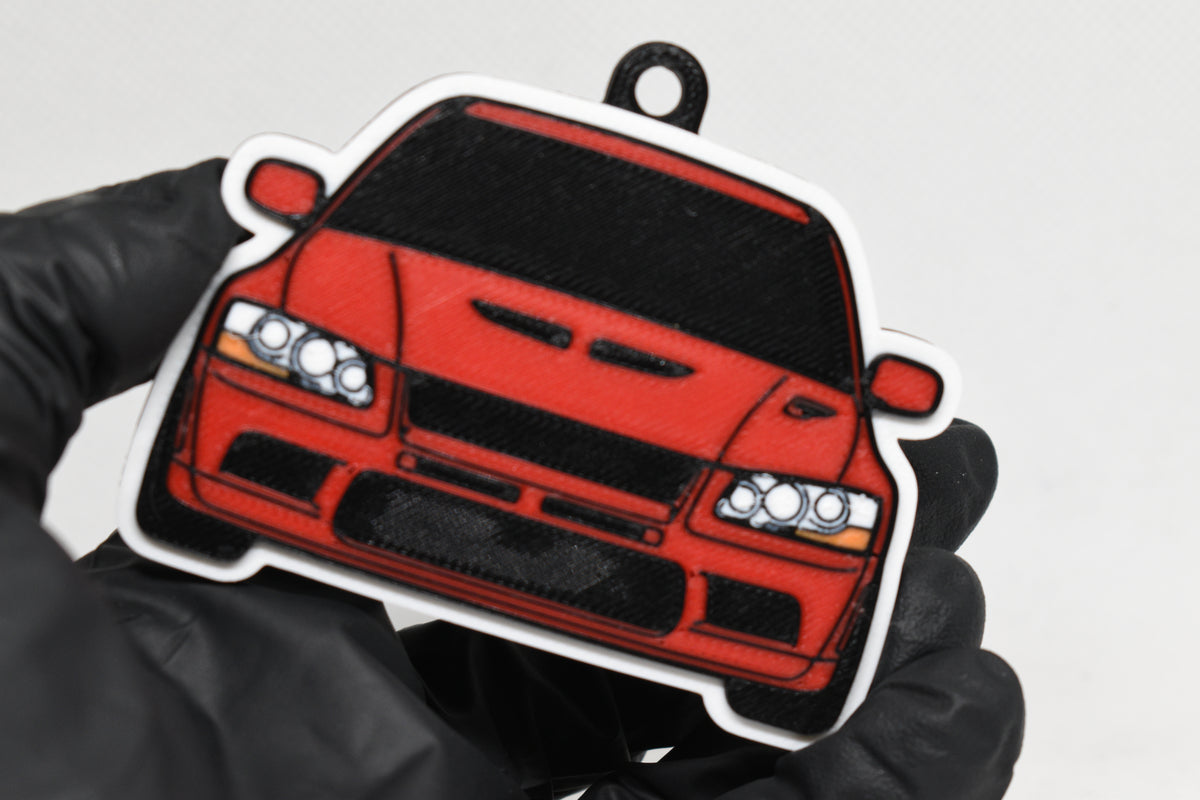 3D printed red Mitsubishi Lancer Evolution 7 keychain held in hand, front view detail by LayerPlay Pocket Motors