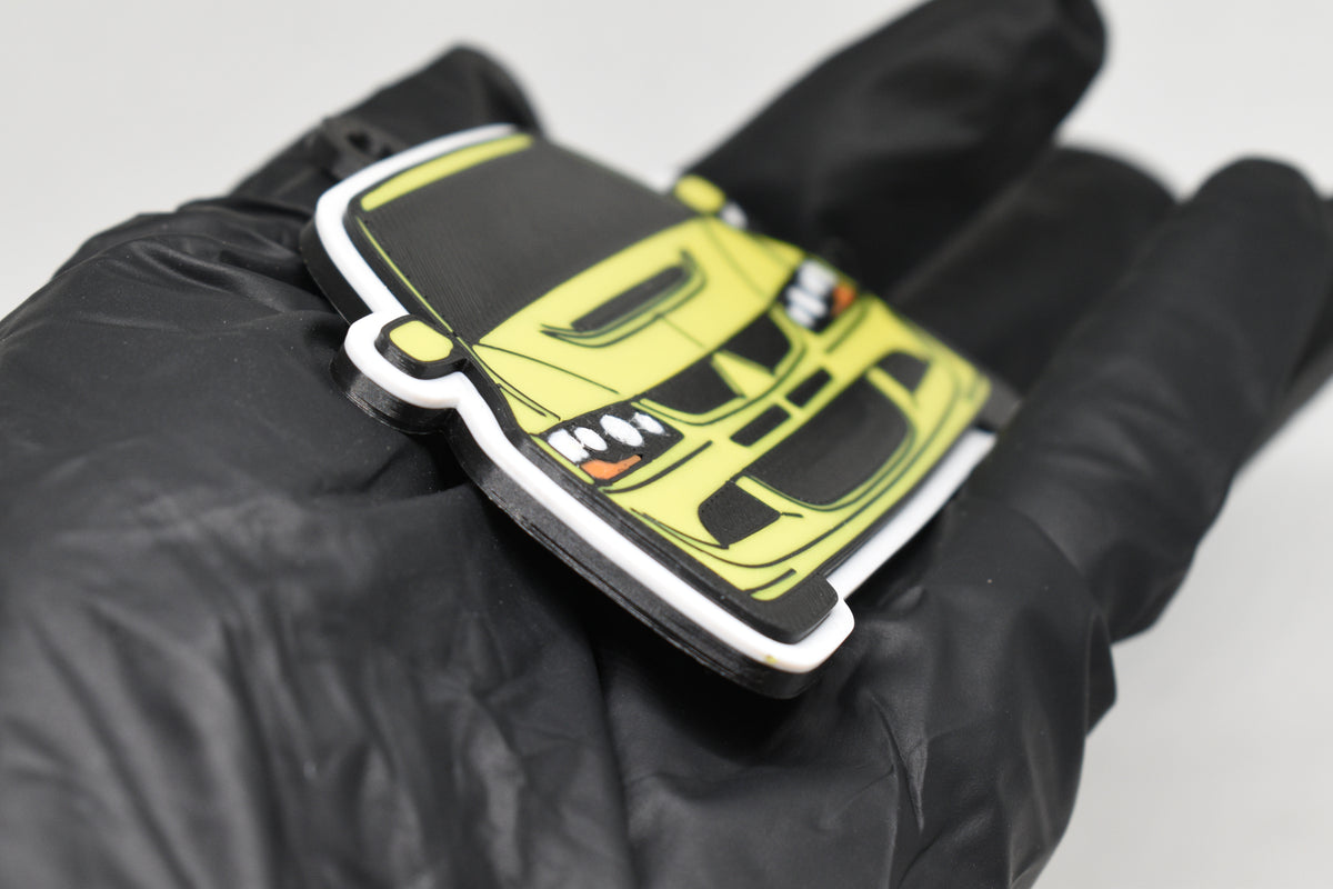 Side angle view showing 3D layered detail of yellow Mitsubishi Lancer Evolution 8 keychain by LayerPlay Pocket Motors