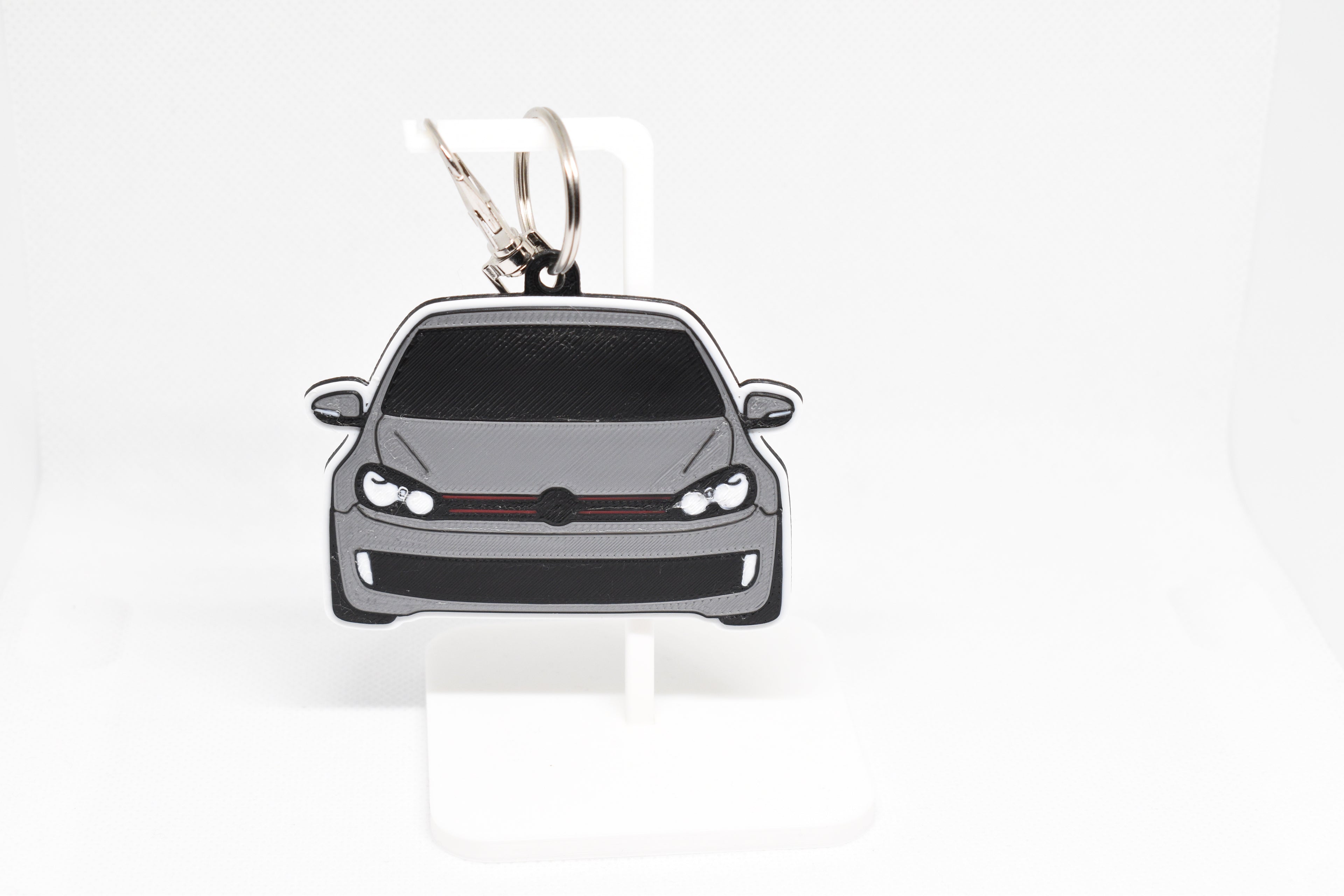 Pocket Motors MK6 GTI keychain displayed on a white stand with metal ring and clip.