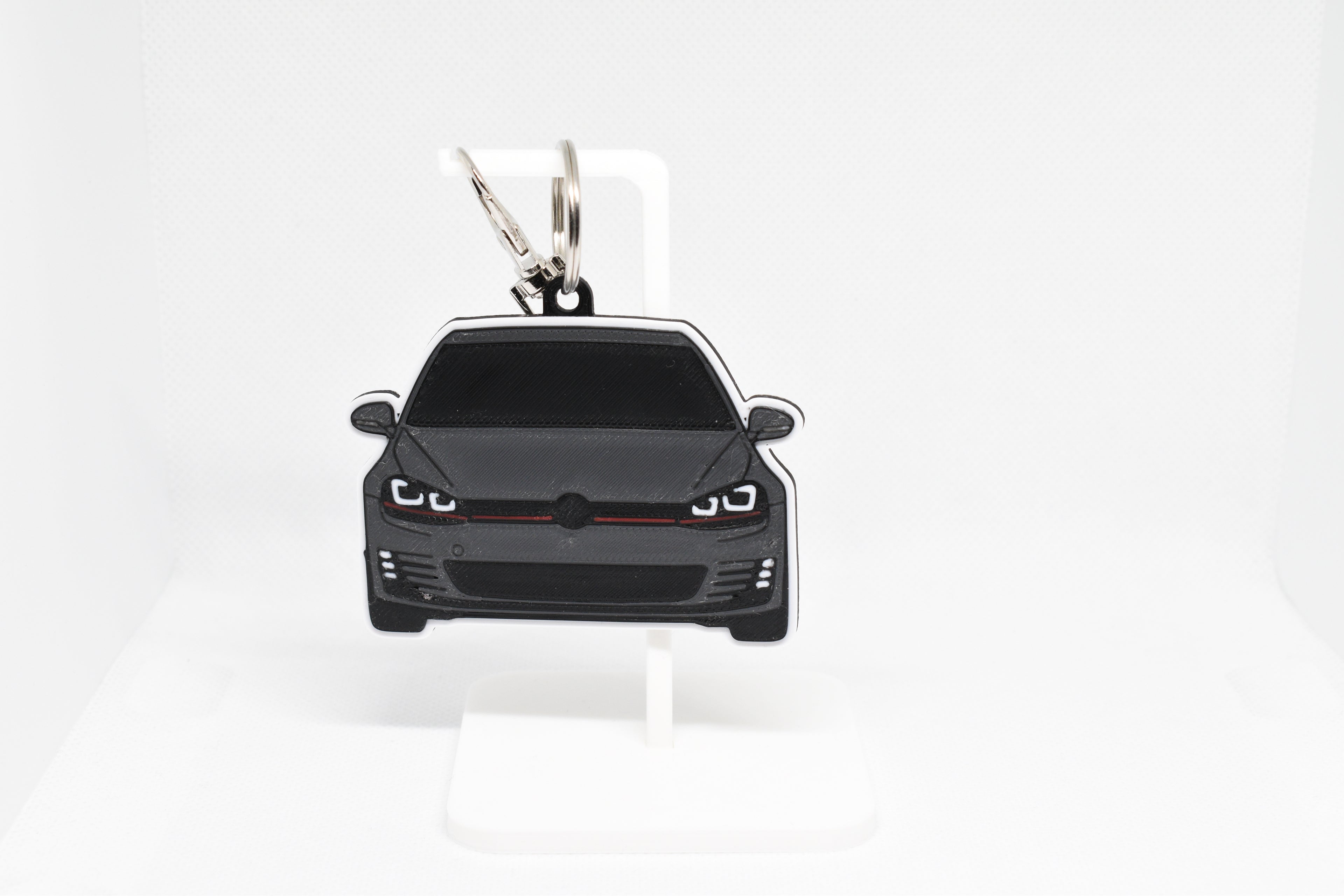 Pocket Motors MK7 GTI keychain displayed on a white stand with metal ring and clip.