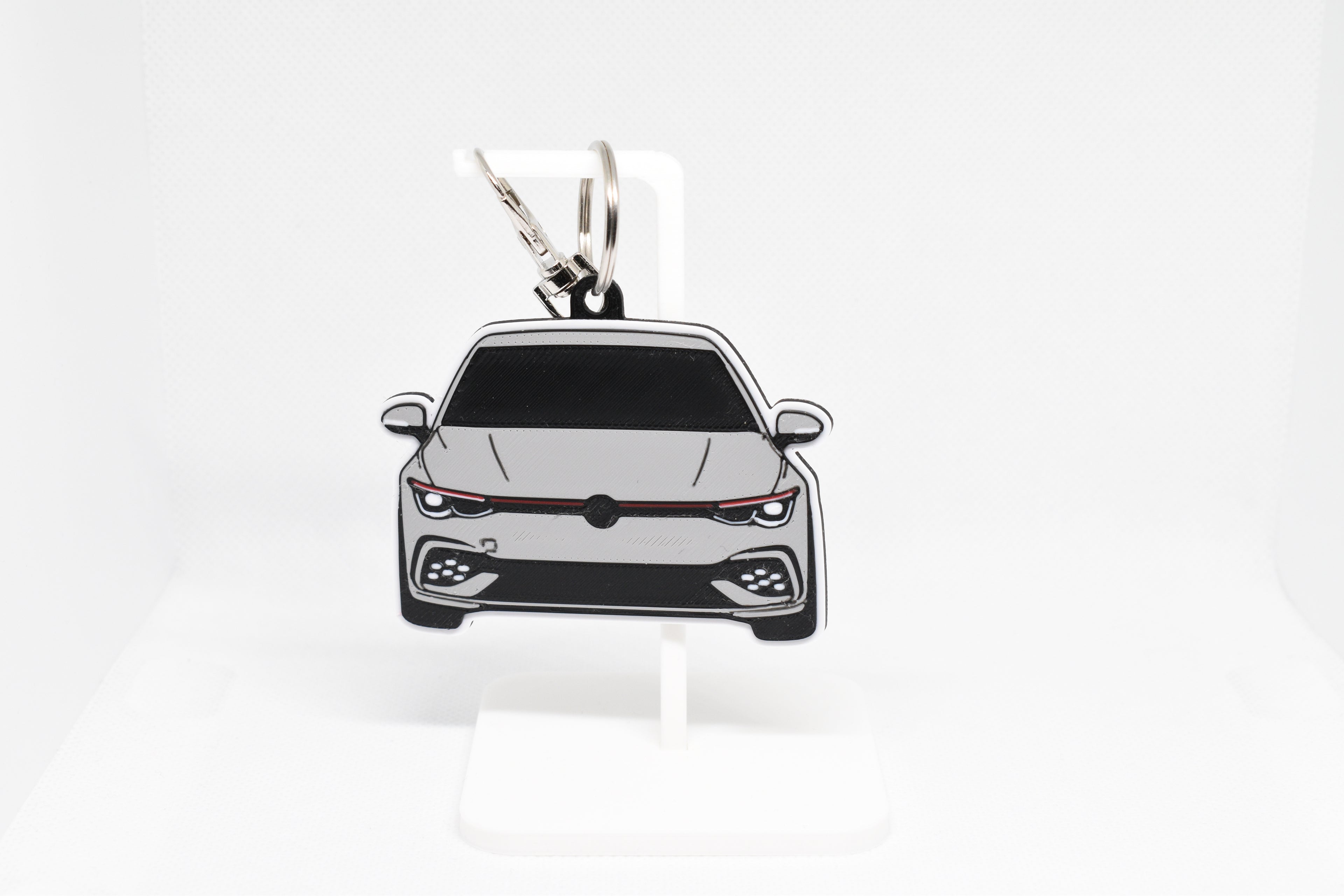 Pocket Motors MK8 GTI keychain displayed on a white stand with metal ring and clip.