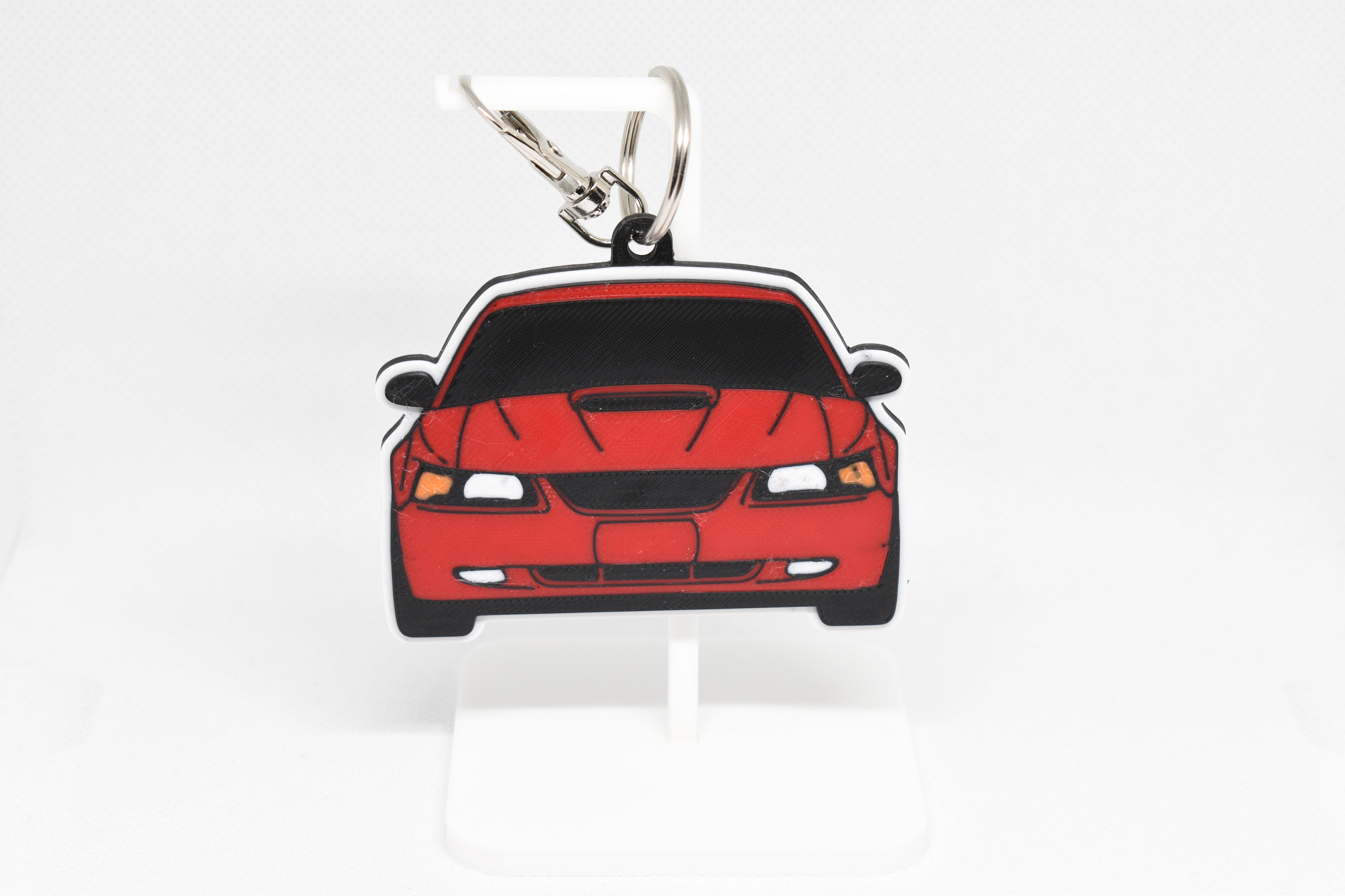 Pocket Motors Mustang GT SN95 facelift keychain displayed on a white stand with metal ring and clip.