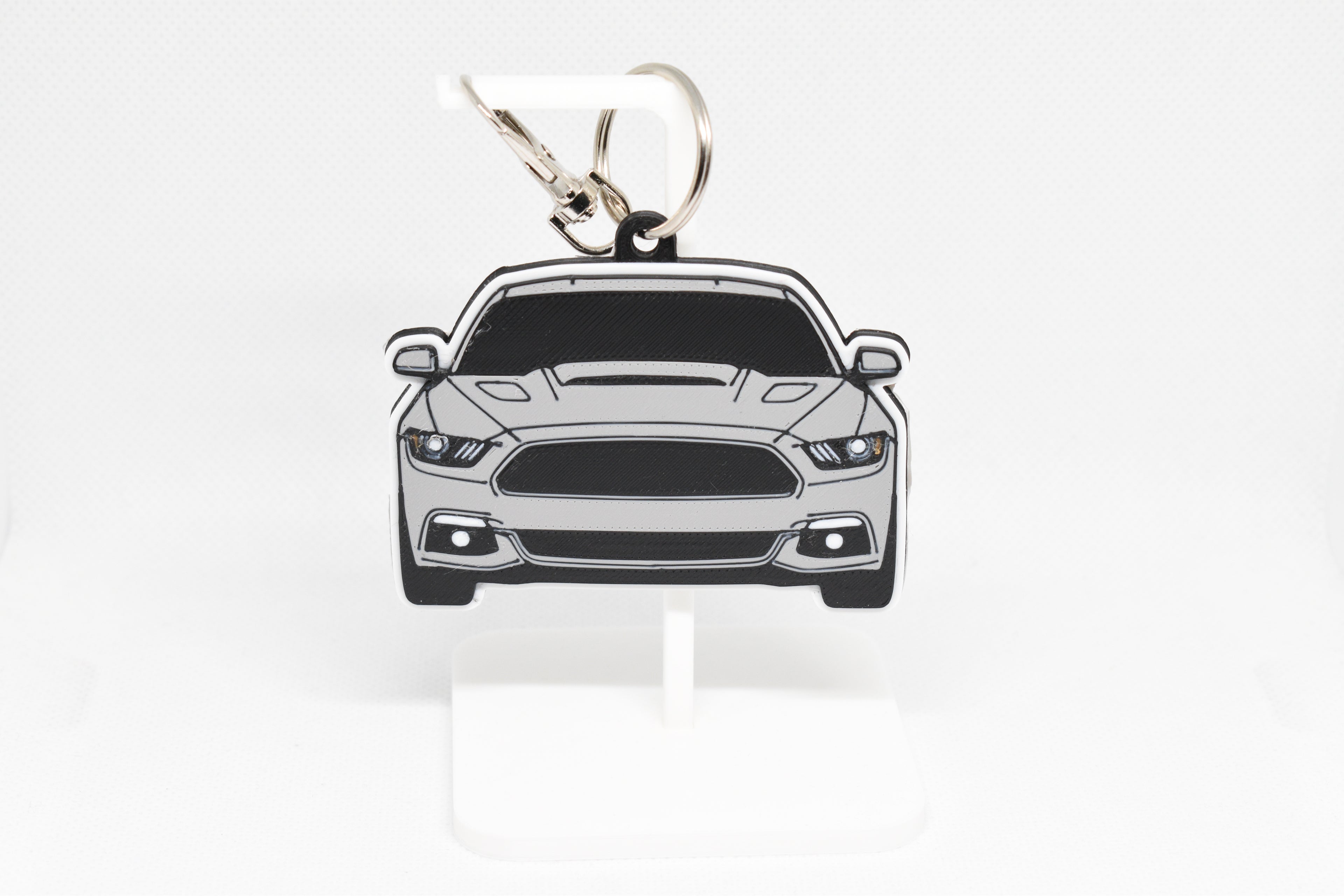 Pocket Motors Mustang S550 keychain displayed on a white stand with metal ring and clip.