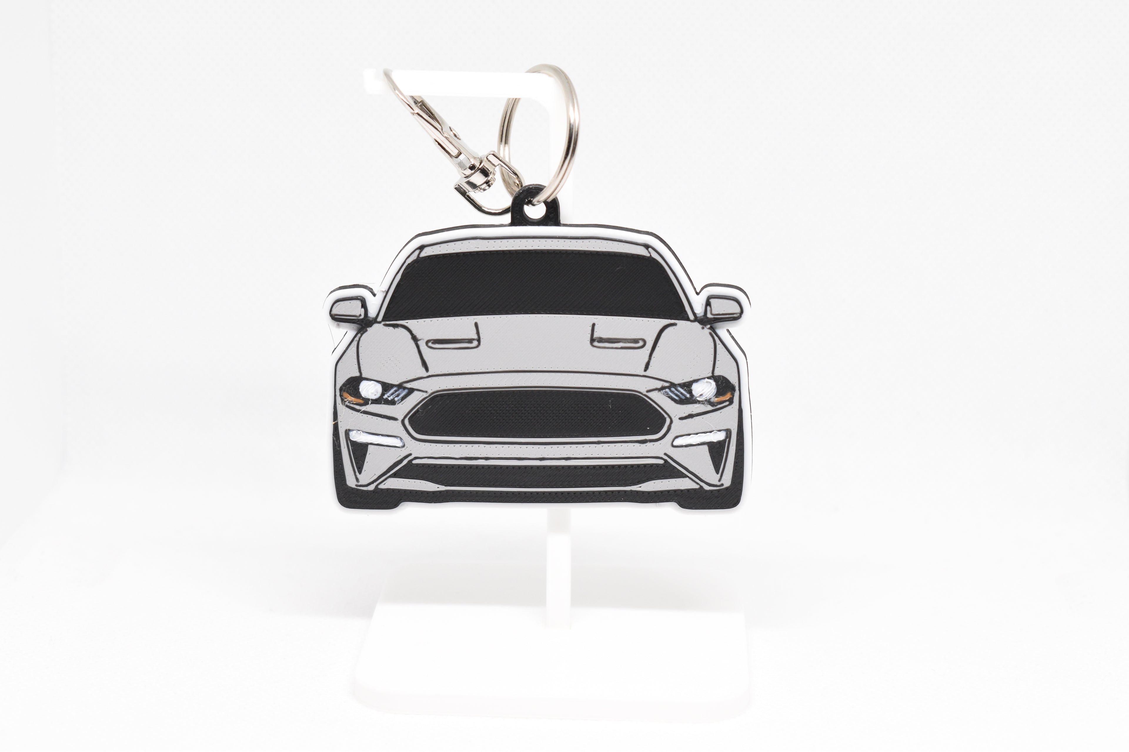 Pocket Motors Mustang S550 facelift keychain displayed on a white stand with metal ring and clip.