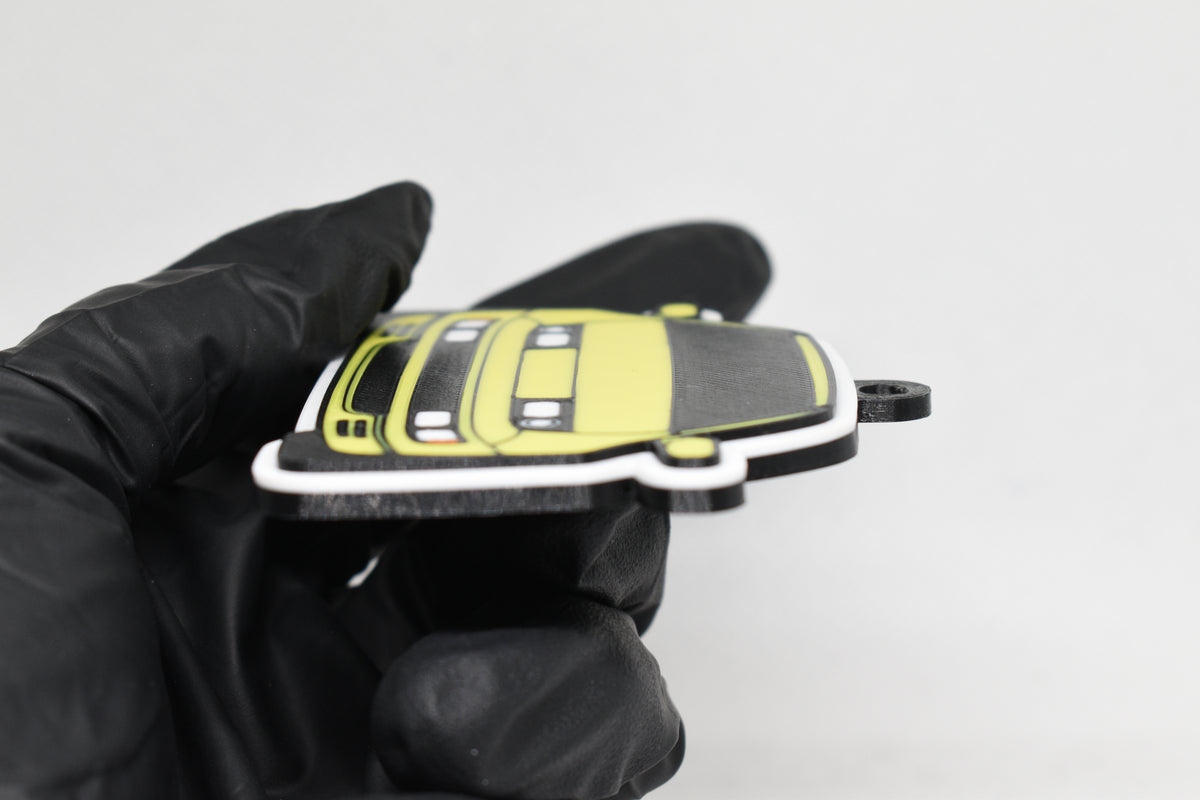 Side angle view showing 3D layered detail of yellow Nissan 300ZX keychain by LayerPlay Pocket Motors