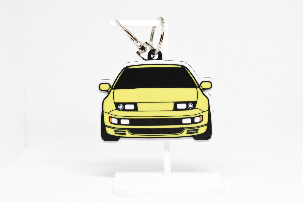 Pocket Motors Nissan 300ZX keychain displayed on a white stand with metal ring and clip.
