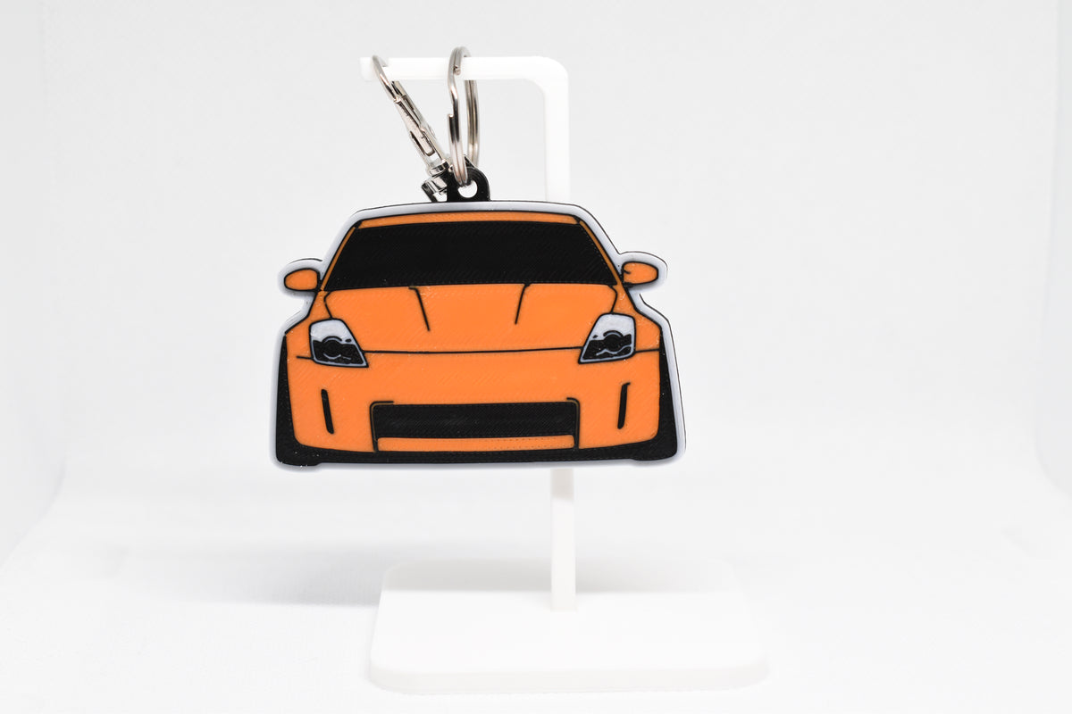 Pocket Motors Nissan 350Z Z33 keychain displayed on a white stand with metal ring and clip.