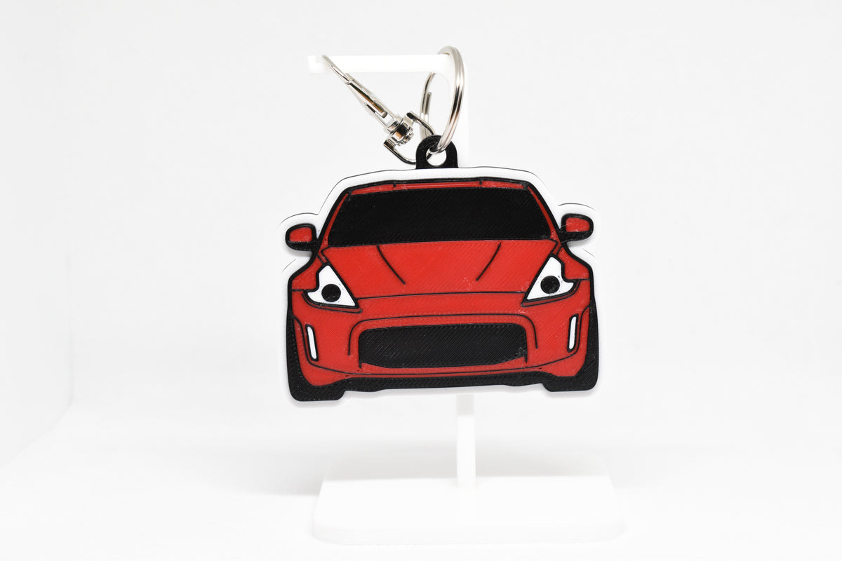 Pocket Motors Nissan 370Z keychain displayed on a white stand with metal ring and clip.