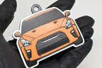 3D printed orange Nissan GT-R R35 keychain held in hand, front view detail by LayerPlay Pocket Motors
