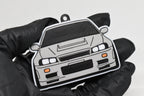 3D printed light gray Nissan Skyline GT-R R34 keychain held in hand, front view detail by LayerPlay Pocket Motors