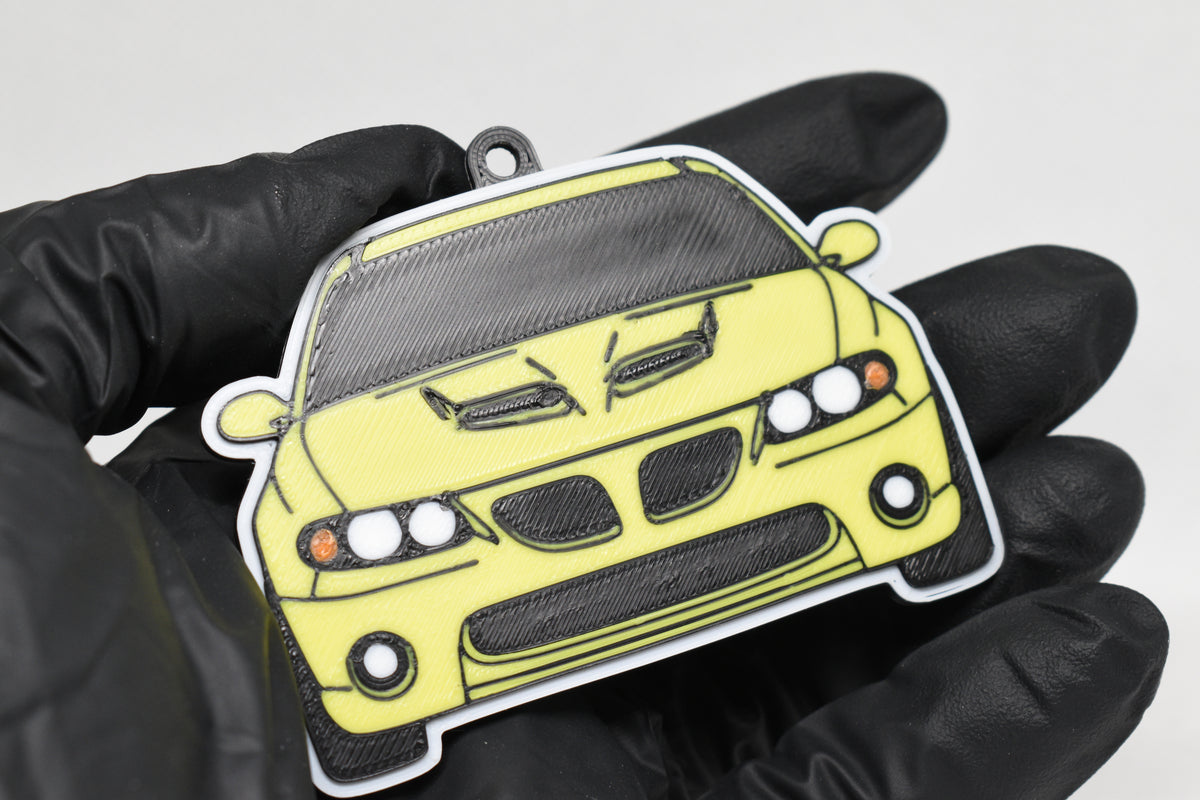 3D printed yellow Pontiac GTO 5th Gen keychain held in hand, front view detail by LayerPlay Pocket Motors