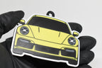 3D printed yellow Porsche 911 Turbo S keychain held in hand, front view detail by LayerPlay Pocket Motors