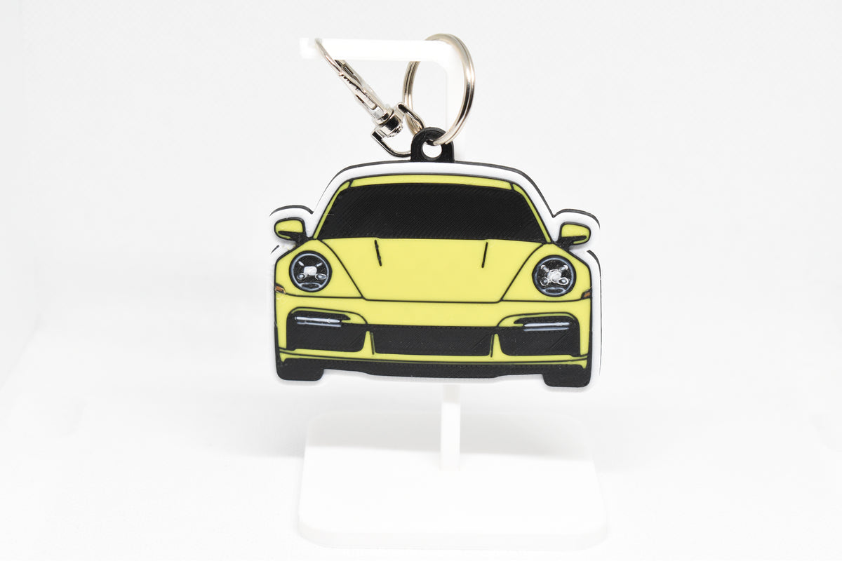 Pocket Motors Porsche 911 Turbo S keychain displayed on a white stand with metal ring and clip.