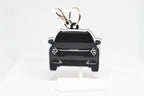 Pocket Motors Sportage keychain displayed on a white stand with metal ring and clip.