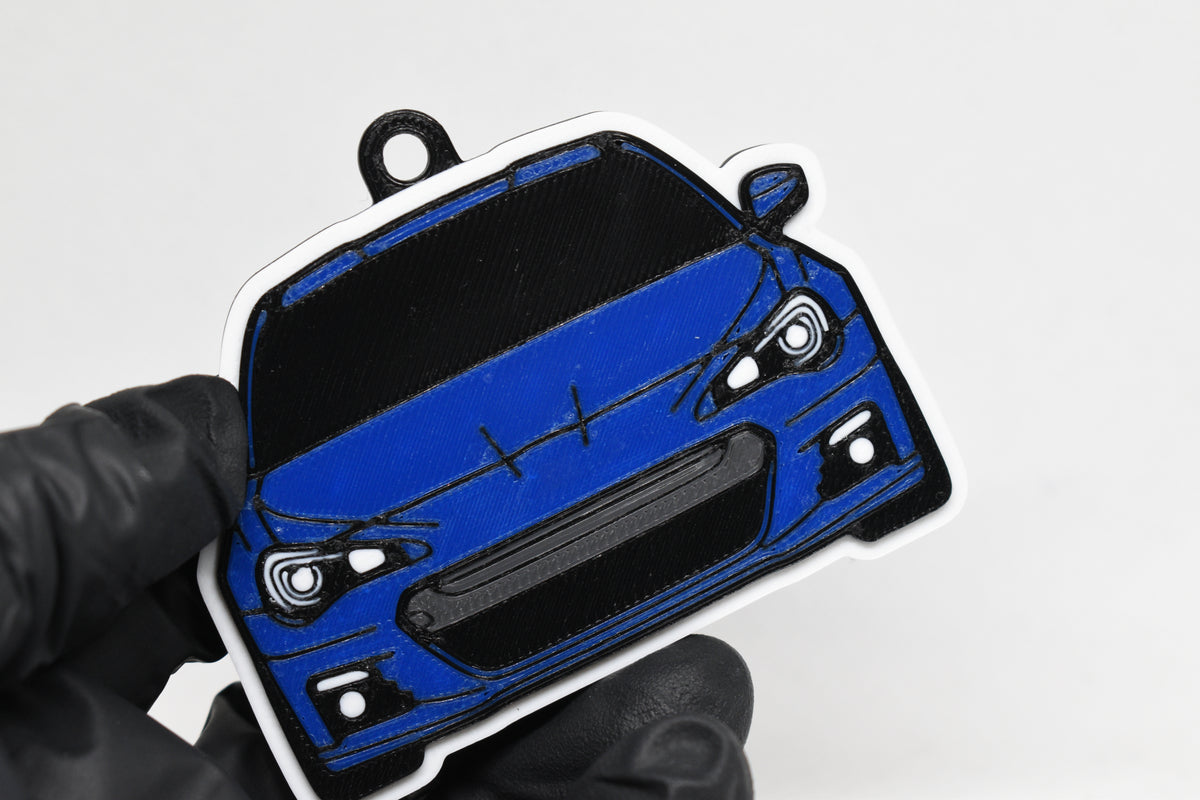 3D printed blue Subaru BRZ 1st Gen keychain held in hand, front view detail by LayerPlay Pocket Motors