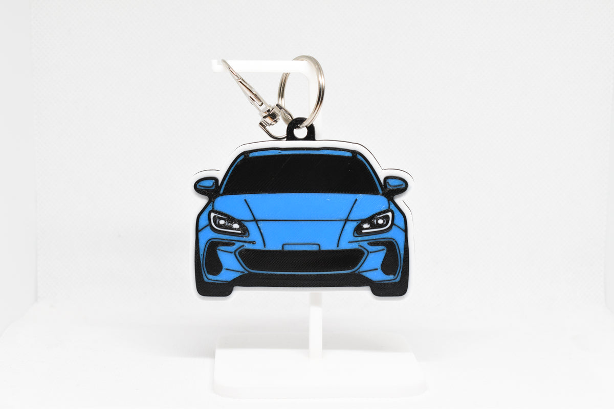 Layerplay Pocket Motors 2nd‑gen Subaru BRZ 3D printed keychain displayed on a white stand.