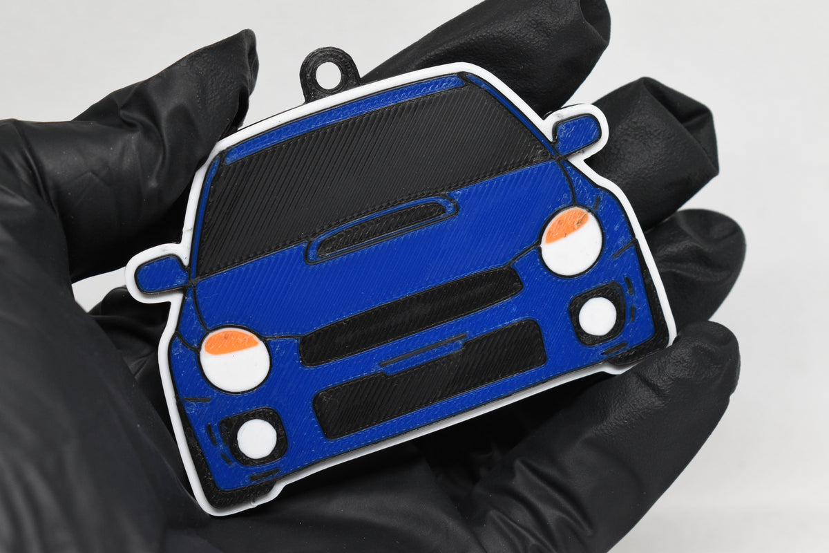 3D printed blue Subaru WRX Bugeye keychain held in hand, front view detail by LayerPlay Pocket Motors
