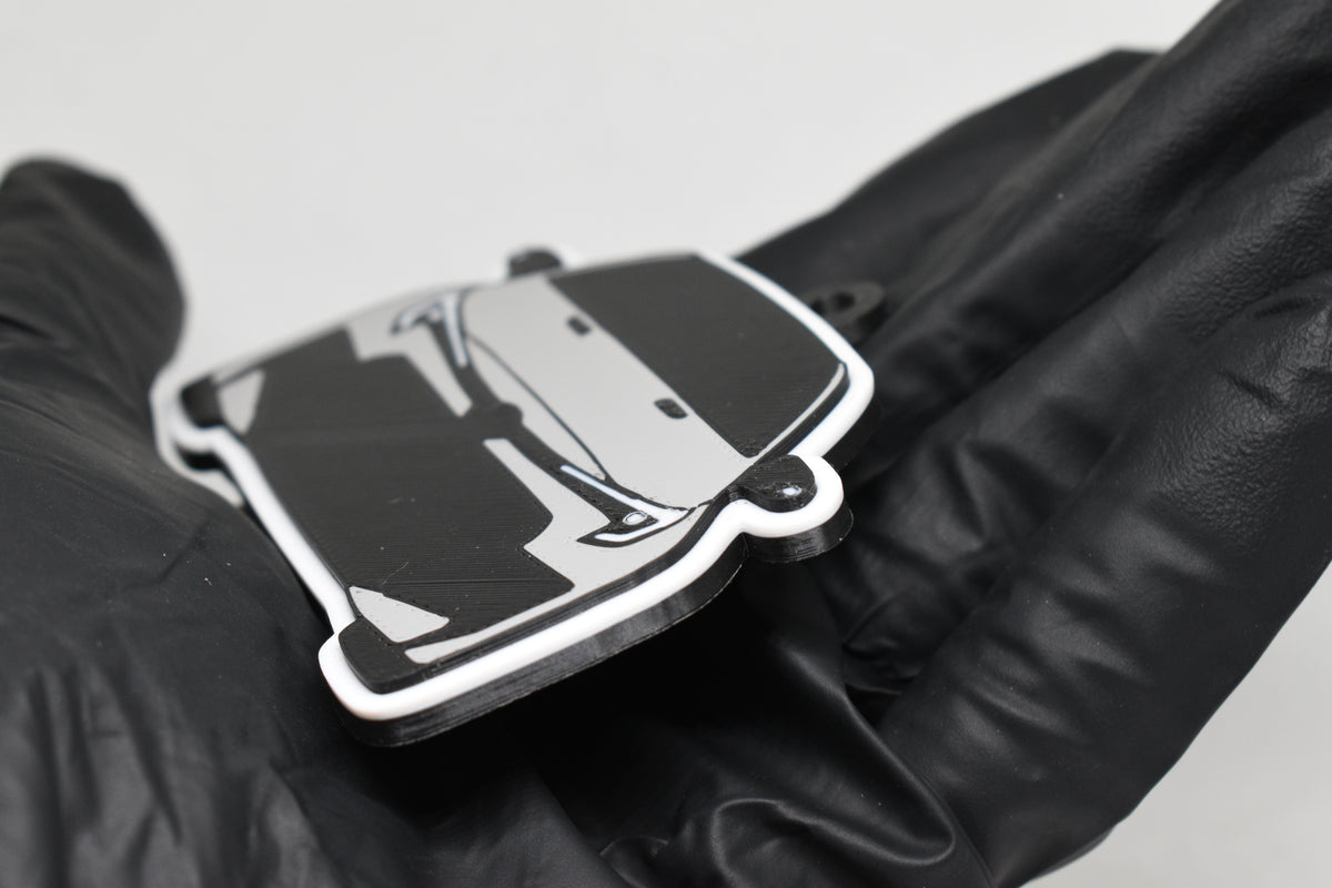 Side angle view showing 3D layered detail of light gray Toyota GR Corolla facelift keychain by LayerPlay Pocket Motors