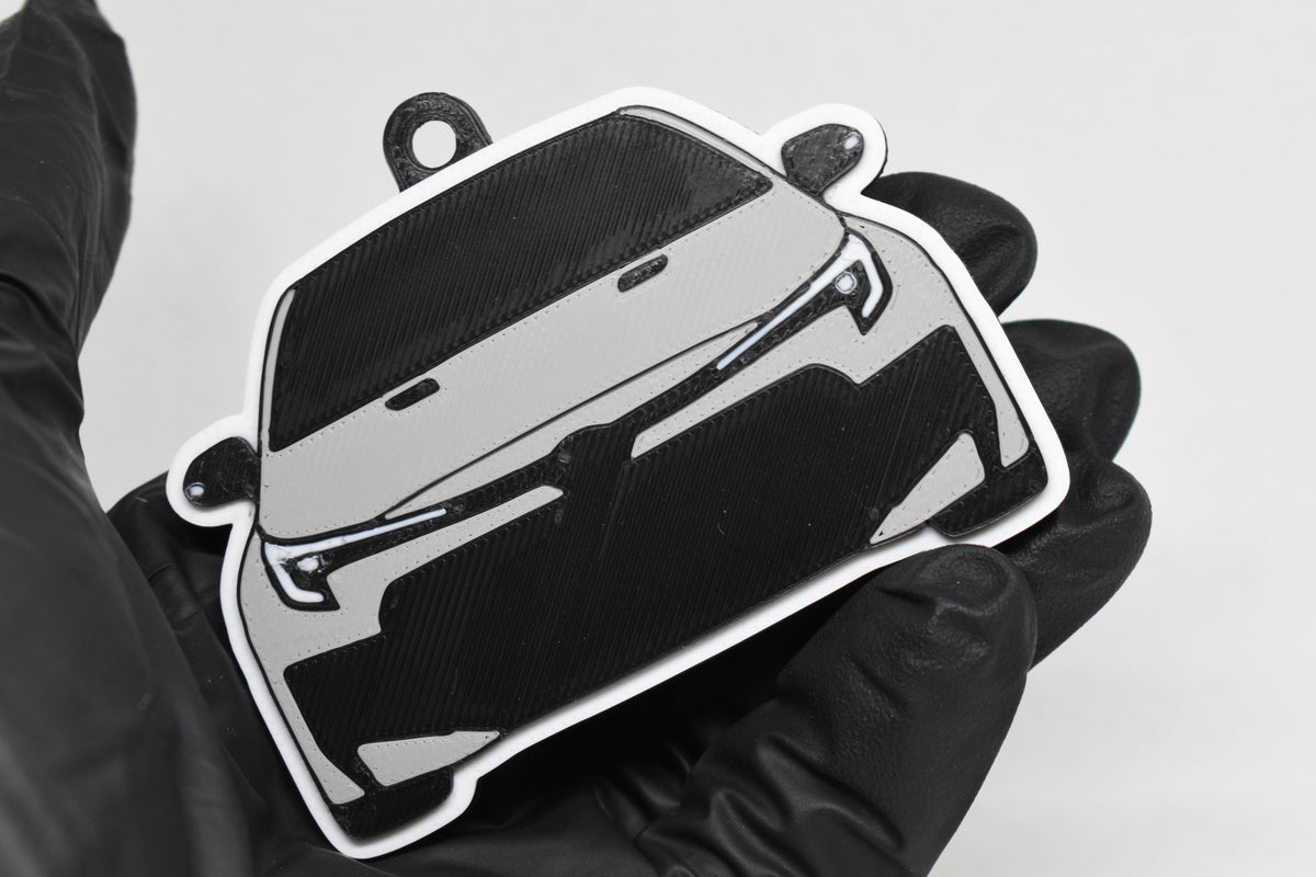 3D printed light gray Toyota GR Corolla facelift keychain held in hand, front view detail by LayerPlay Pocket Motors