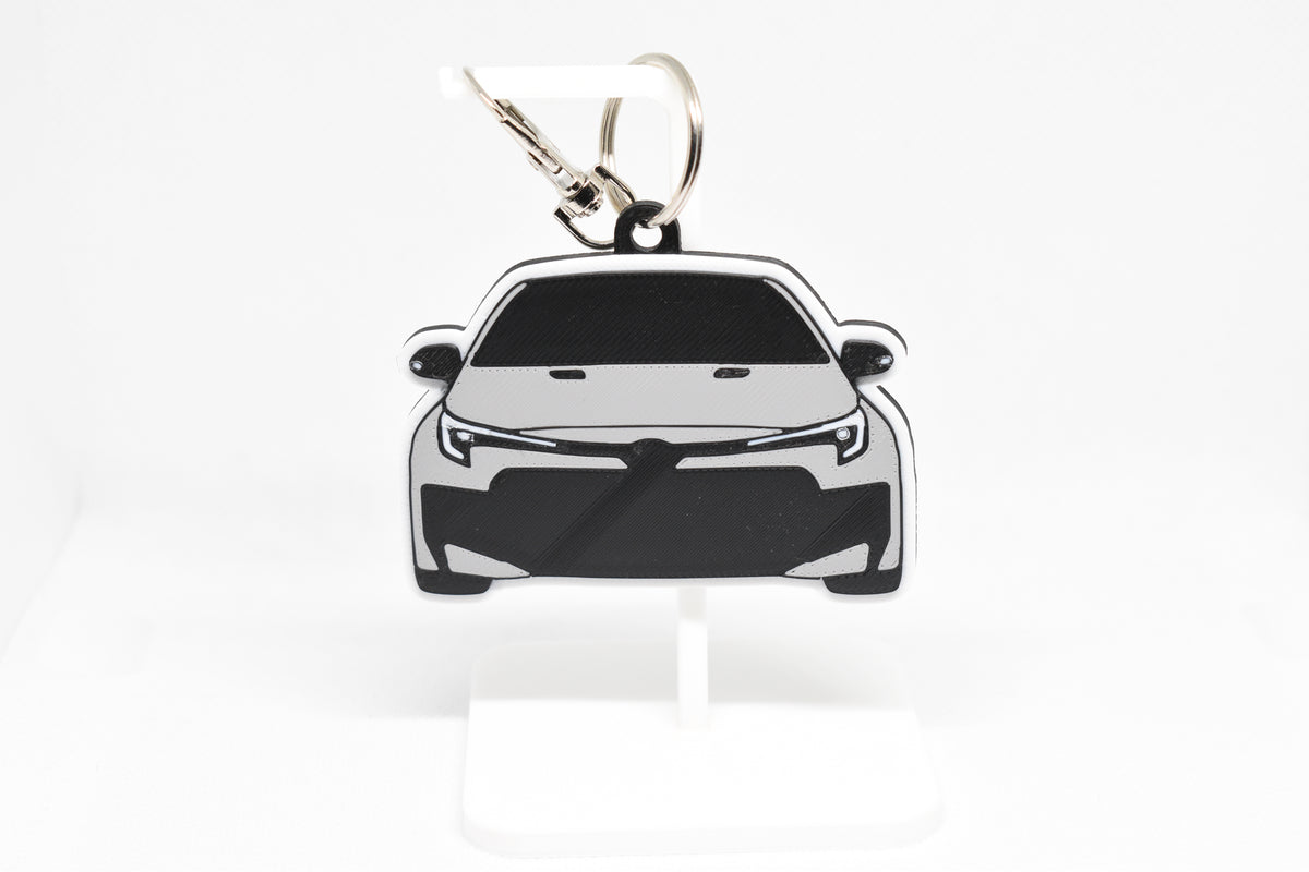 Pocket Motors Toyota GR Corolla facelift keychain displayed on a white stand with metal ring and clip.