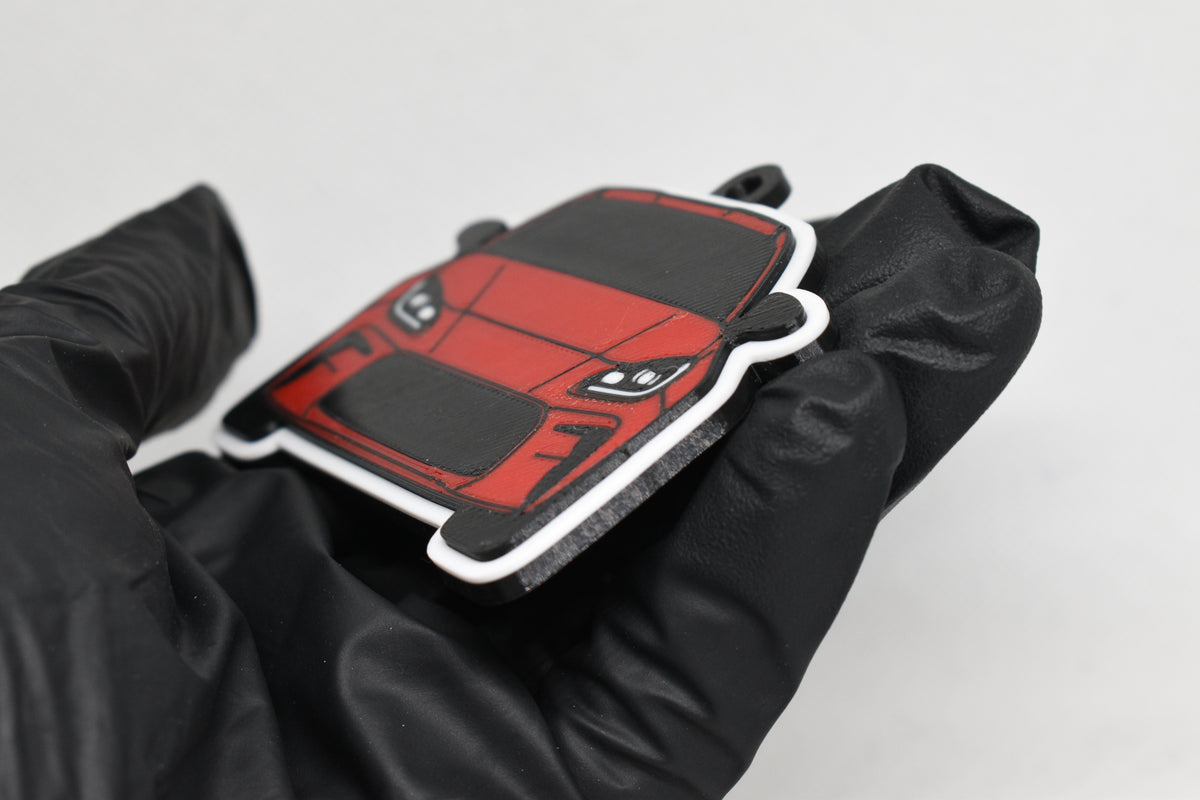 Side angle view showing 3D layered detail of red Toyota GR86 keychain by LayerPlay Pocket Motors