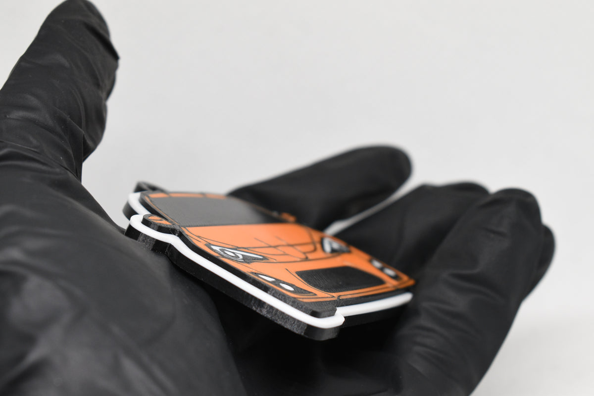 Side angle view showing 3D layered detail of orange Toyota GT86 keychain by LayerPlay Pocket Motors