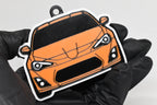3D printed orange Toyota GT86 keychain held in hand, front view detail by LayerPlay Pocket Motors