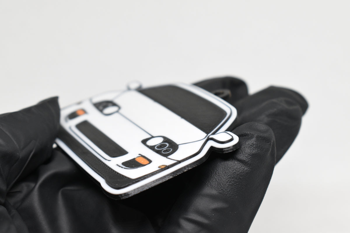 Side angle view showing 3D layered detail of white Toyota Supra Mk4 keychain by LayerPlay Pocket Motors