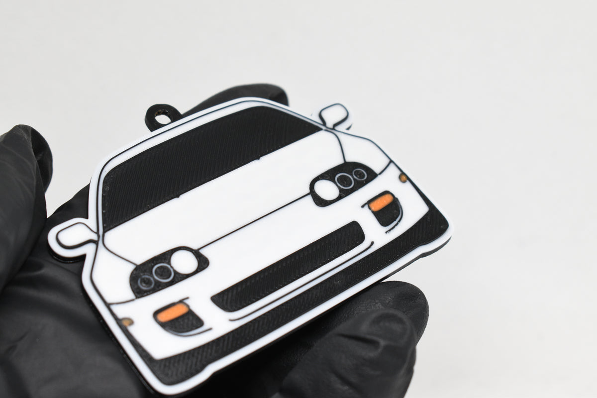 3D printed white Toyota Supra Mk4 keychain held in hand, front view detail by LayerPlay Pocket Motors