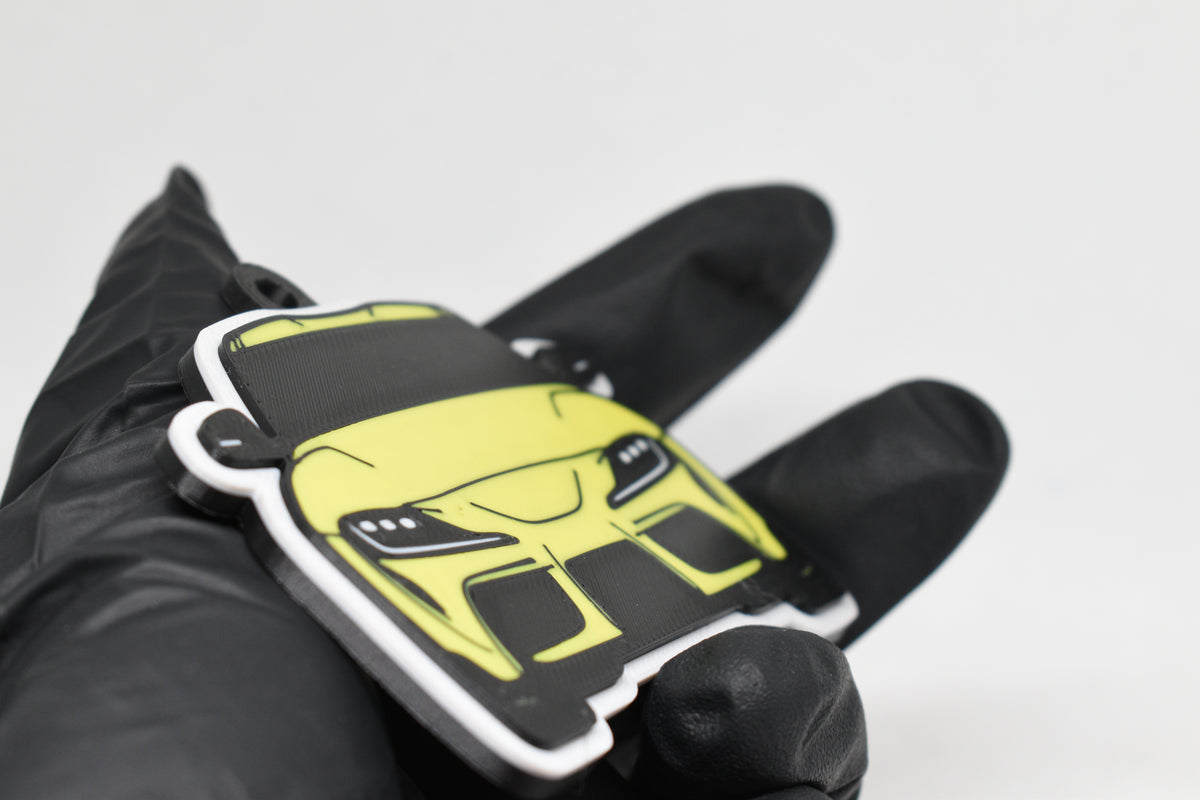 Side angle view showing 3D layered detail of yellow Toyota Supra Mk5 keychain by LayerPlay Pocket Motors