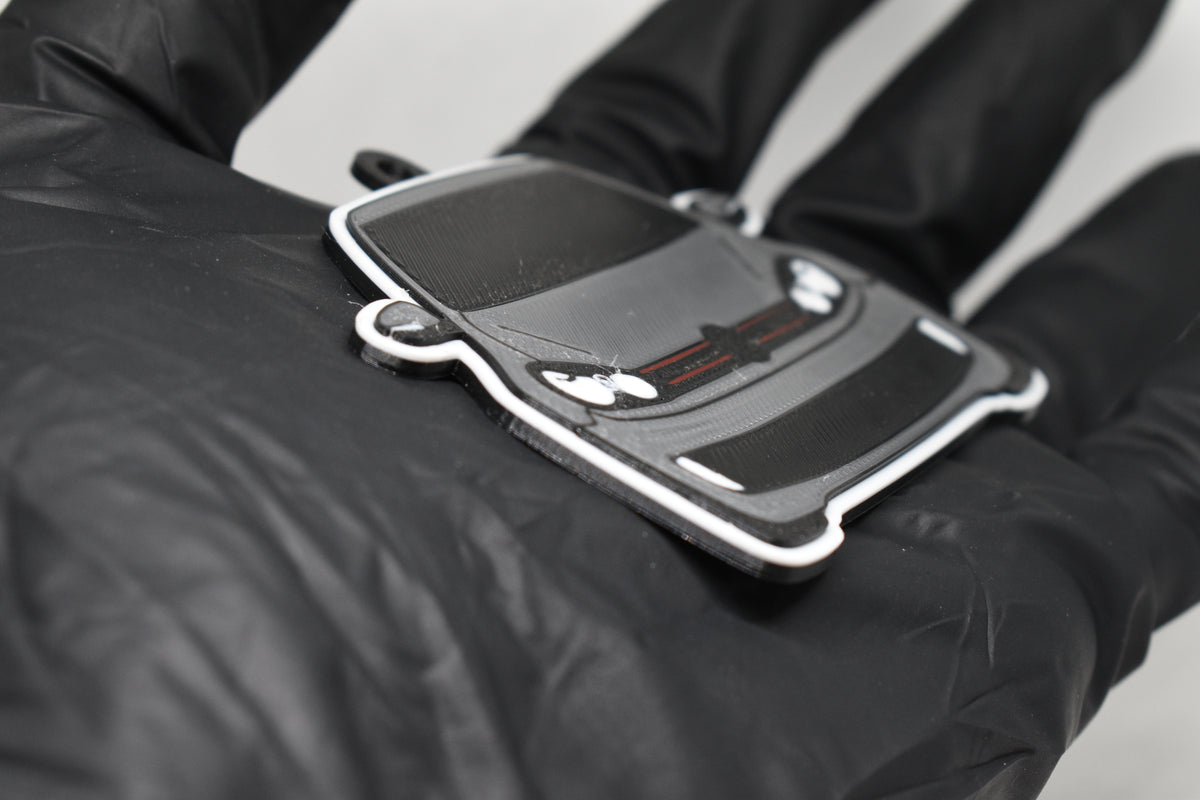 Side angle view showing 3D layered detail of light gray Volkswagen GTI MK6 keychain by LayerPlay Pocket Motors