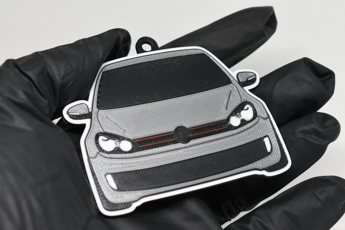 3D printed light gray Volkswagen GTI MK6 keychain held in hand, front view detail by LayerPlay Pocket Motors
