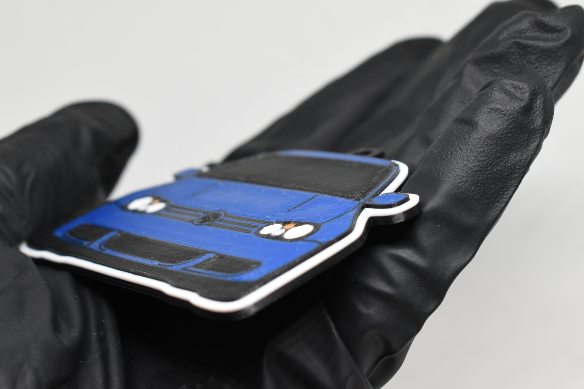 Side angle view showing 3D layered detail of blue Volkswagen MK4 Golf R32 keychain by LayerPlay Pocket Motors