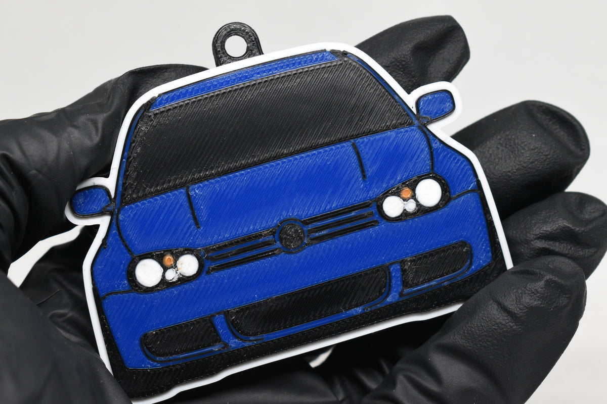 3D printed blue Volkswagen MK4 Golf R32 keychain held in hand, front view detail by LayerPlay Pocket Motors