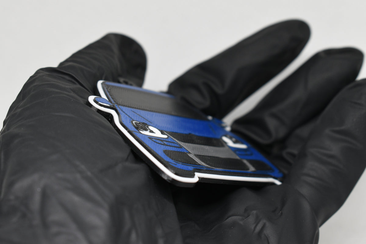 Side angle view showing 3D layered detail of blue Volkswagen MK5 Golf R32 keychain by LayerPlay Pocket Motors