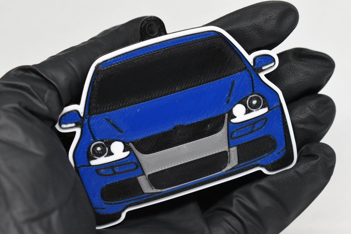 3D printed blue Volkswagen MK5 Golf R32 keychain held in hand, front view detail by LayerPlay Pocket Motors