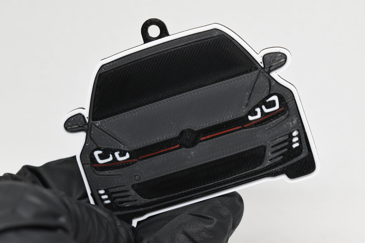 3D printed space gray and black Volkswagen MK7 GTI keychain held in hand, front view detail by LayerPlay Pocket Motors