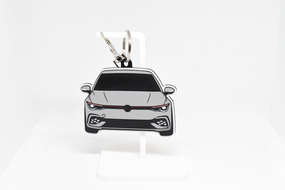 Pocket Motors Volkswagen MK8 GTI keychain displayed on a white stand with metal ring and clip.