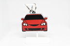 Red RSX keychain displayed on a white stand with metal ring and clip.