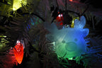 3D printed translucent reindeer ornament hanging on a white Christmas tree glowing with colorful tree light illumination.