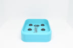 Low side angle studio view of cyan rectangular soap holder with raised domino nubs by LayerPlay Solara