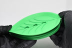 Hands in black gloves demonstrating two-piece removable drainage design of green leaf soap dish by LayerPlay Solara