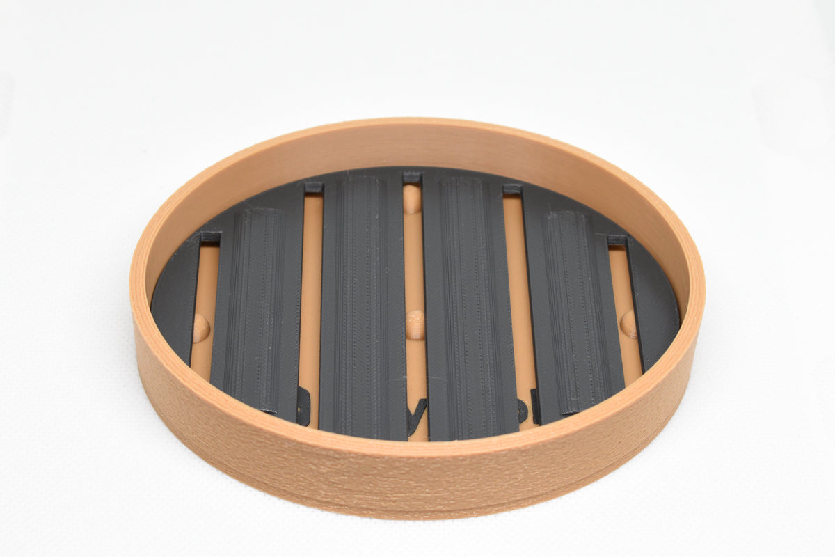 Top studio view of assembled two tone 3D printed tan and black round slotted soap holder by LayerPlay Solara
