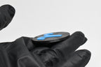Side angle view showing raised 3D blue aries sign detail and thickness on black disc keychain by LayerPlay