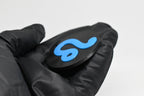 Side angle view showing raised 3D blue leo sign detail and thickness on black disc keychain by LayerPlay