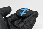 Side angle view showing raised 3D blue sagittarius sign detail and thickness on black disc keychain by LayerPlay
