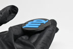 Side angle view showing raised 3D blue virgo sign detail and thickness on black disc keychain by LayerPlay